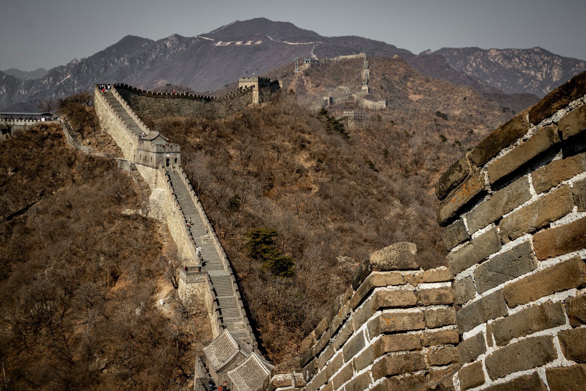 Great Wall of China snaking over forested mountains near the Mutianyu section, Beijing