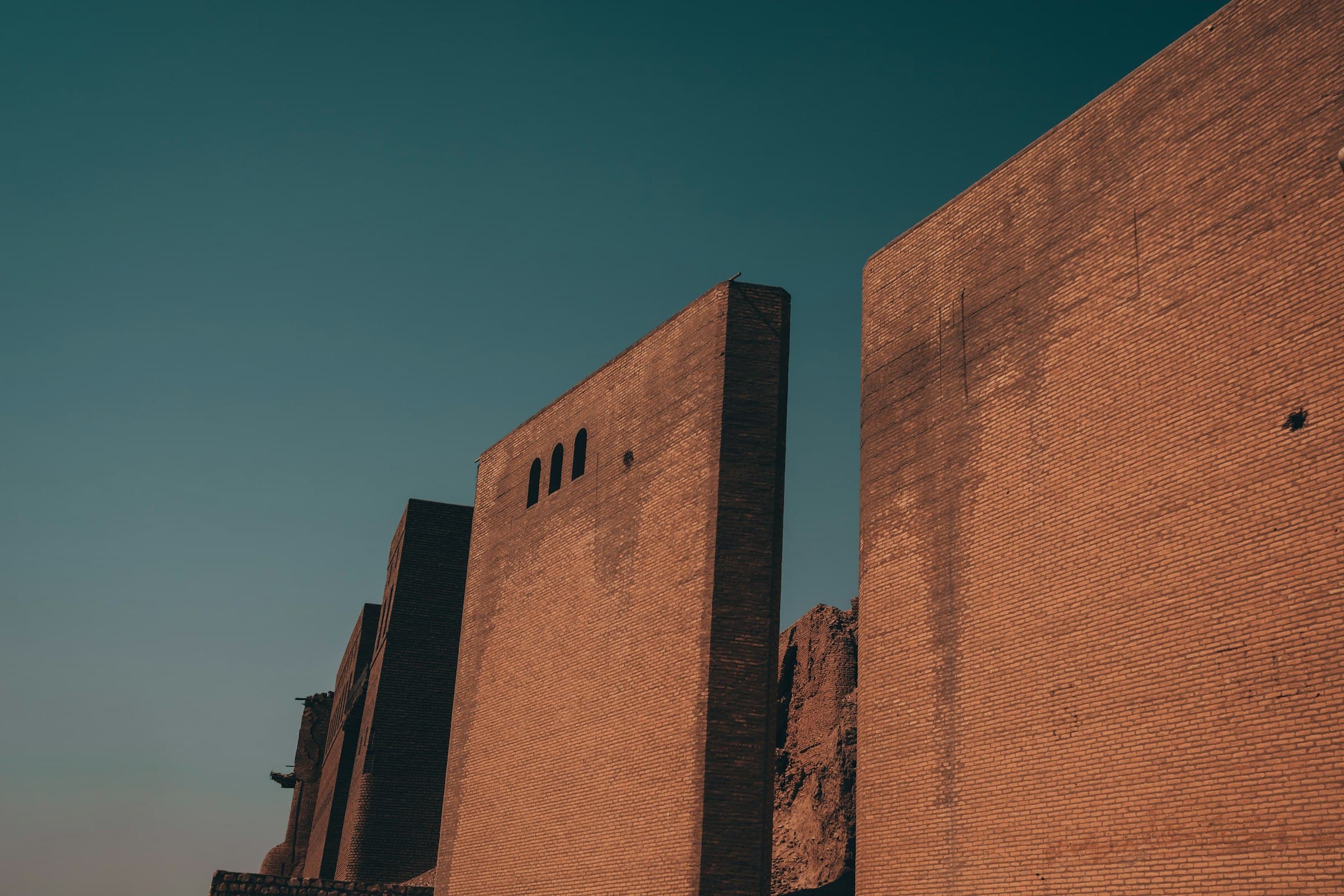 The ancient brick walls of Erbil Citadel rising against a clear evening sky in Erbil, Kurdistan Region of Iraq