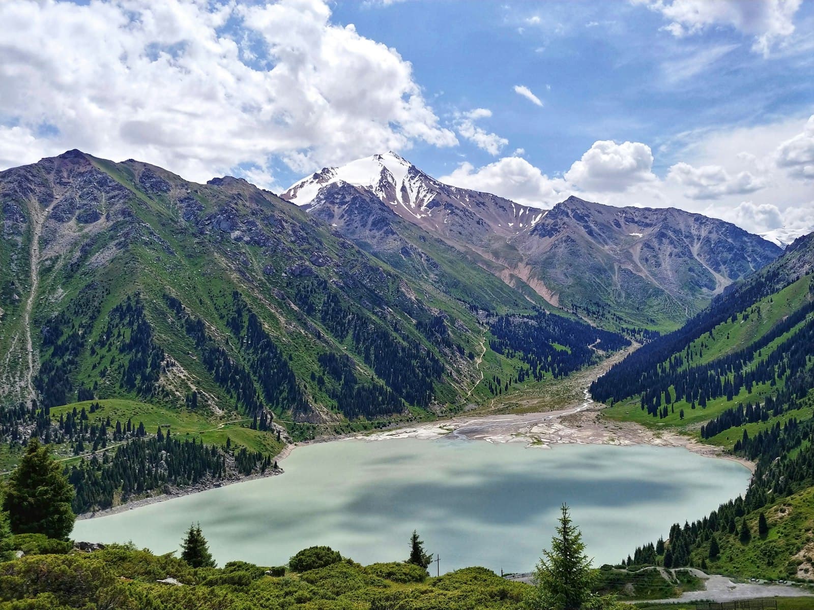 Big Almaty Lake ringed by the snow-capped peaks of the Zailiysky Alatau range, Kazakhstan