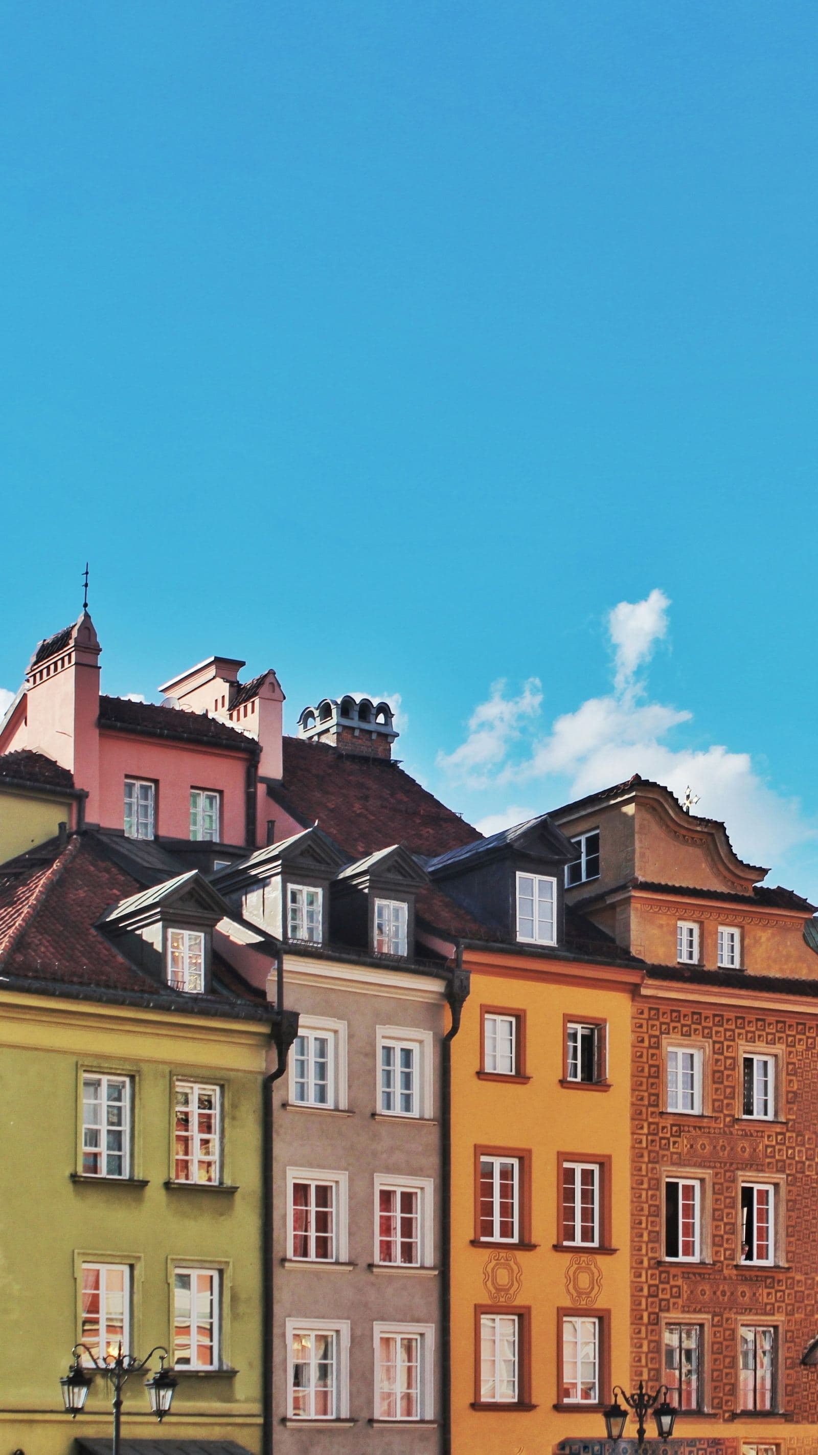 Colourful historic townhouses of the Old Town Market Place in Warsaw, Poland, under a blue sky