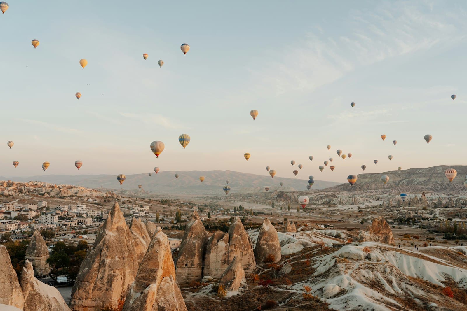 Hot air balloons over the fairy chimneys of Cappadocia, Türkiye, at sunrise
